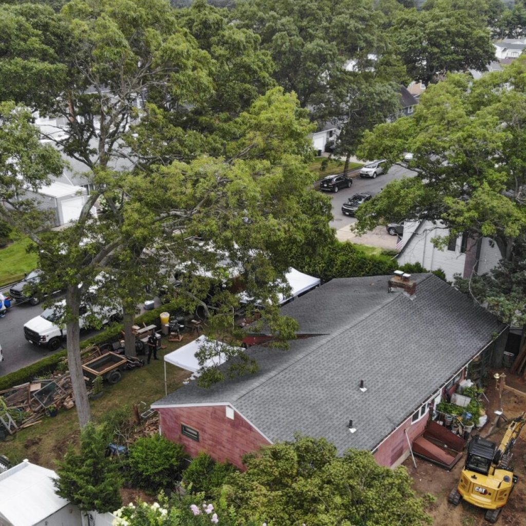 Excavator seen digging in backyard of man charged in Gilgo Beach killings | AP News