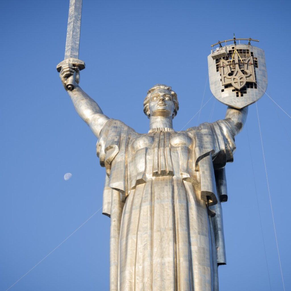 Ukraine replaces Soviet hammer and sickle with trident on towering Kyiv monument | AP News