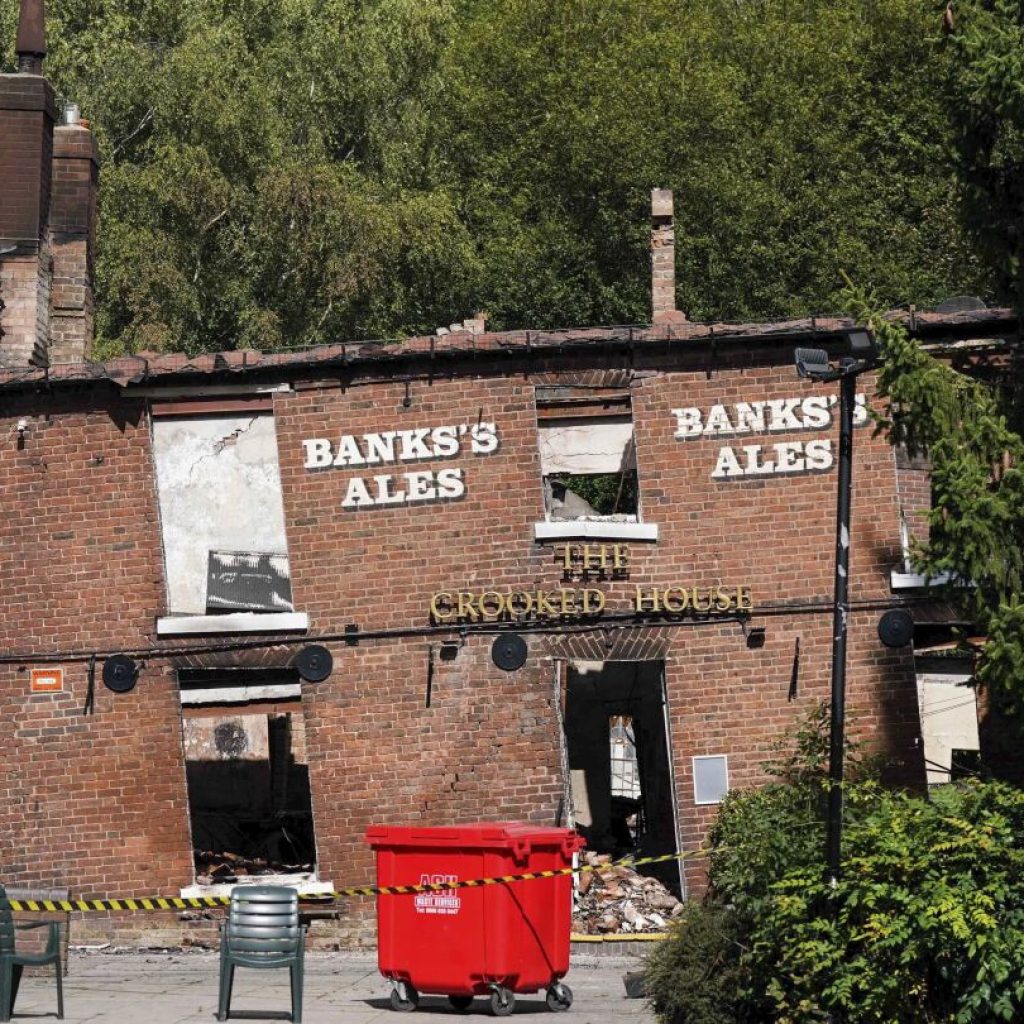 Police arrest two men in suspected torching of British pub cherished for its lopsided walls | AP News