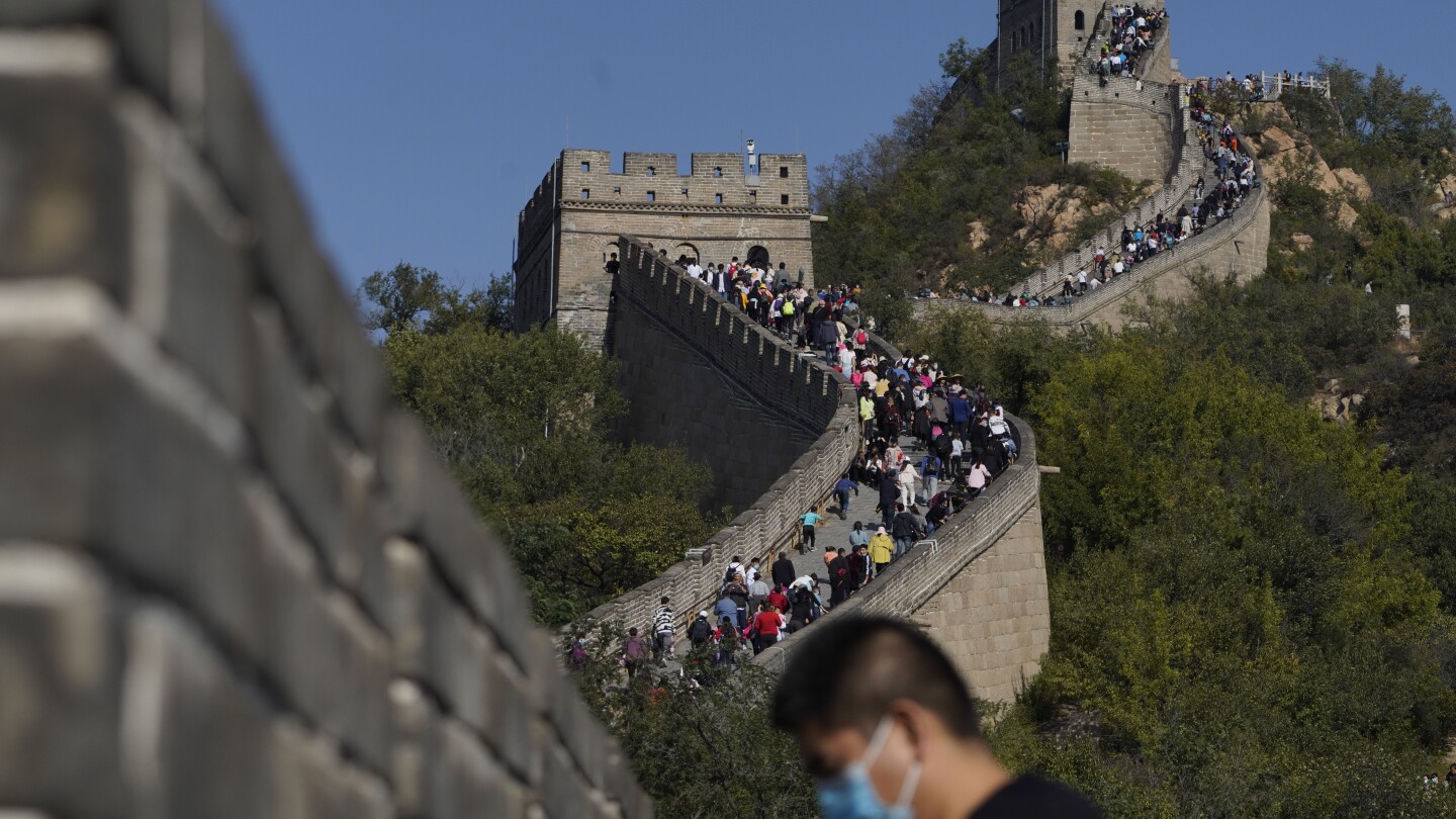 China authorities arrest 2 for smashing shortcut through Great Wall with excavator | AP News