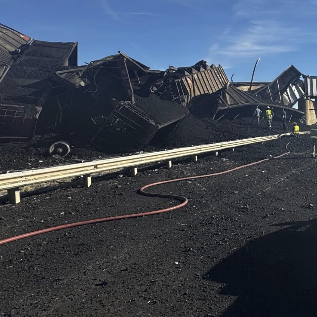 Colorado train derails, spilling train cars and coal onto a highway and trapping a semi-truck driver | AP News