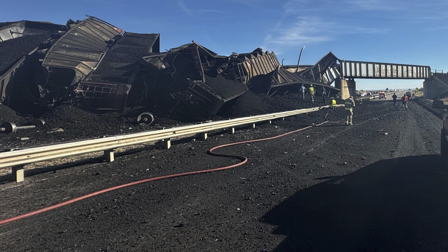 Colorado train derails, spilling train cars and coal onto a highway and trapping a semi-truck driver | AP News