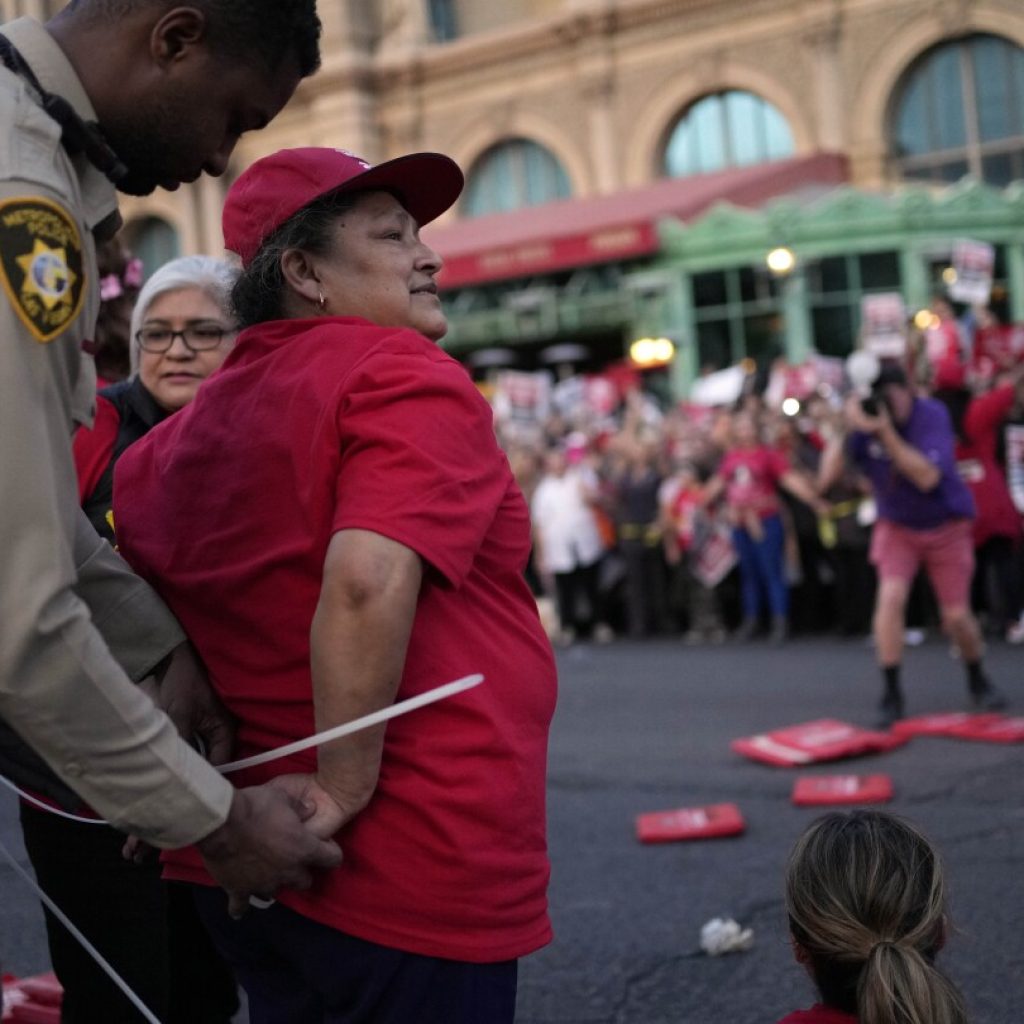 Dozens of union workers arrested on Las Vegas Strip for blocking traffic as thousands rally | AP News