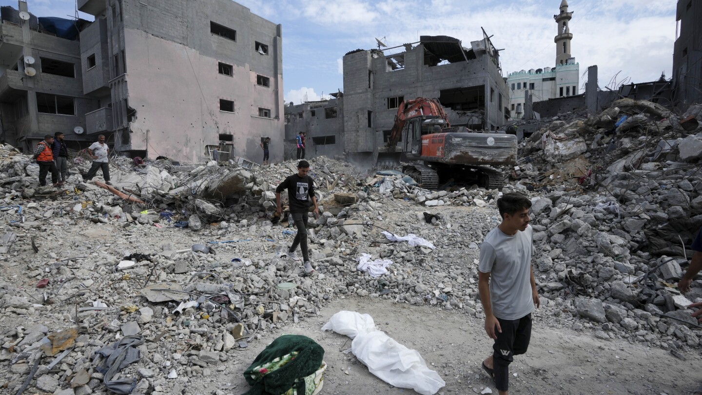 Israel-Hamas war: Families dig by hand to retrieve bodies buried in Gaza rubble | AP News