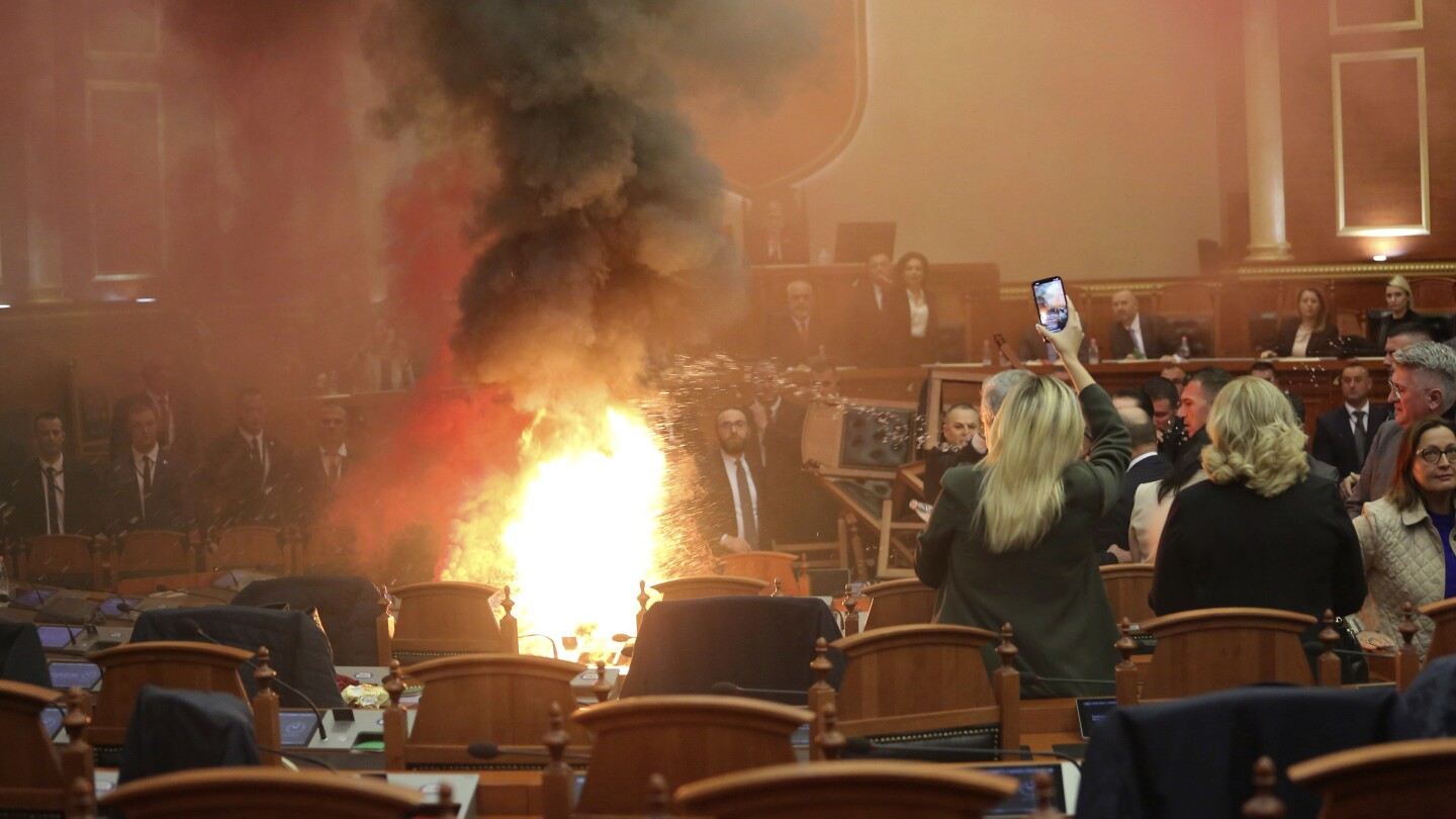 The Albanian opposition disrupts a Parliament vote on the budget with flares and piled-up chairs | AP News