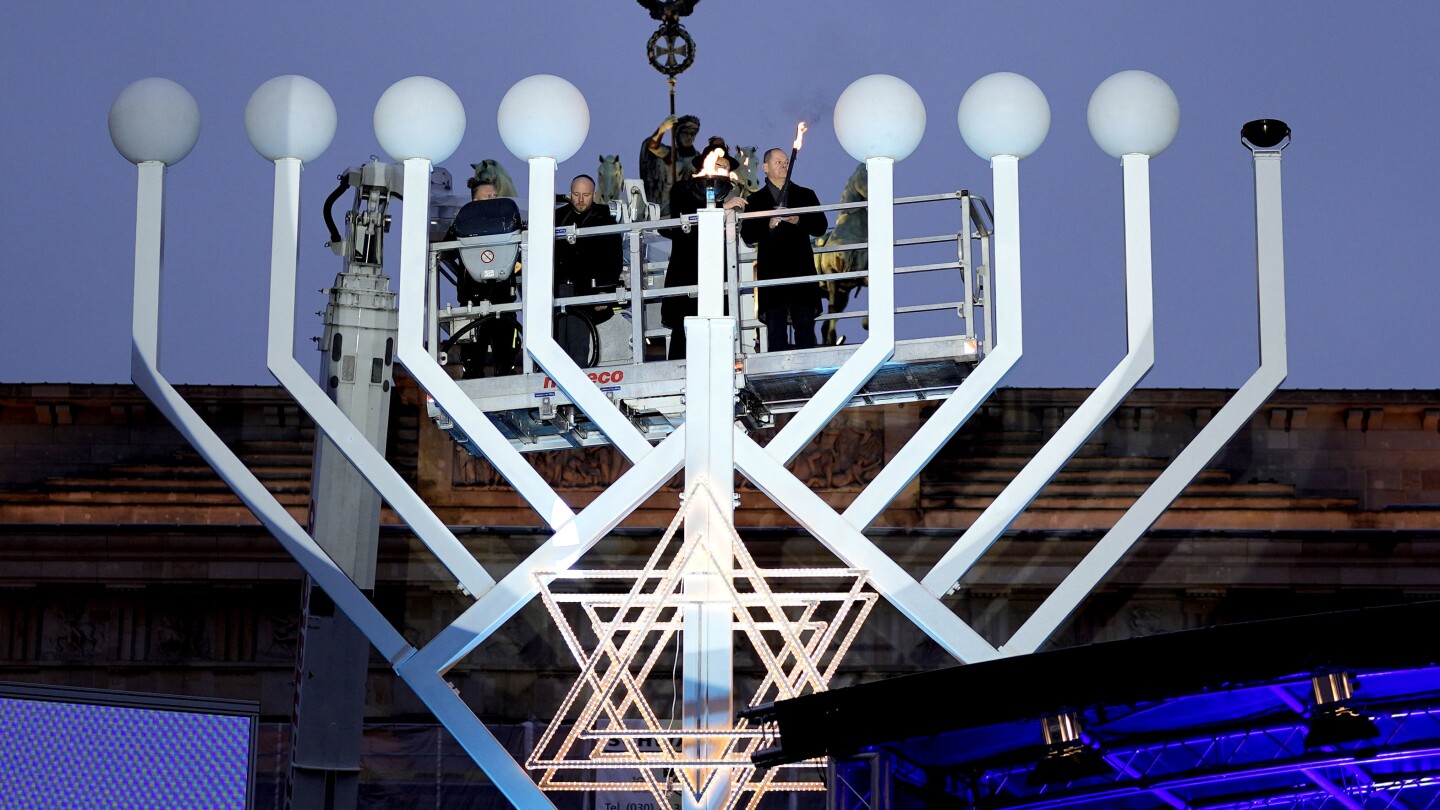 Germany’s chancellor lights first Hanukkah candle on a huge menorah at Berlin’s Brandenburg Gate | AP News