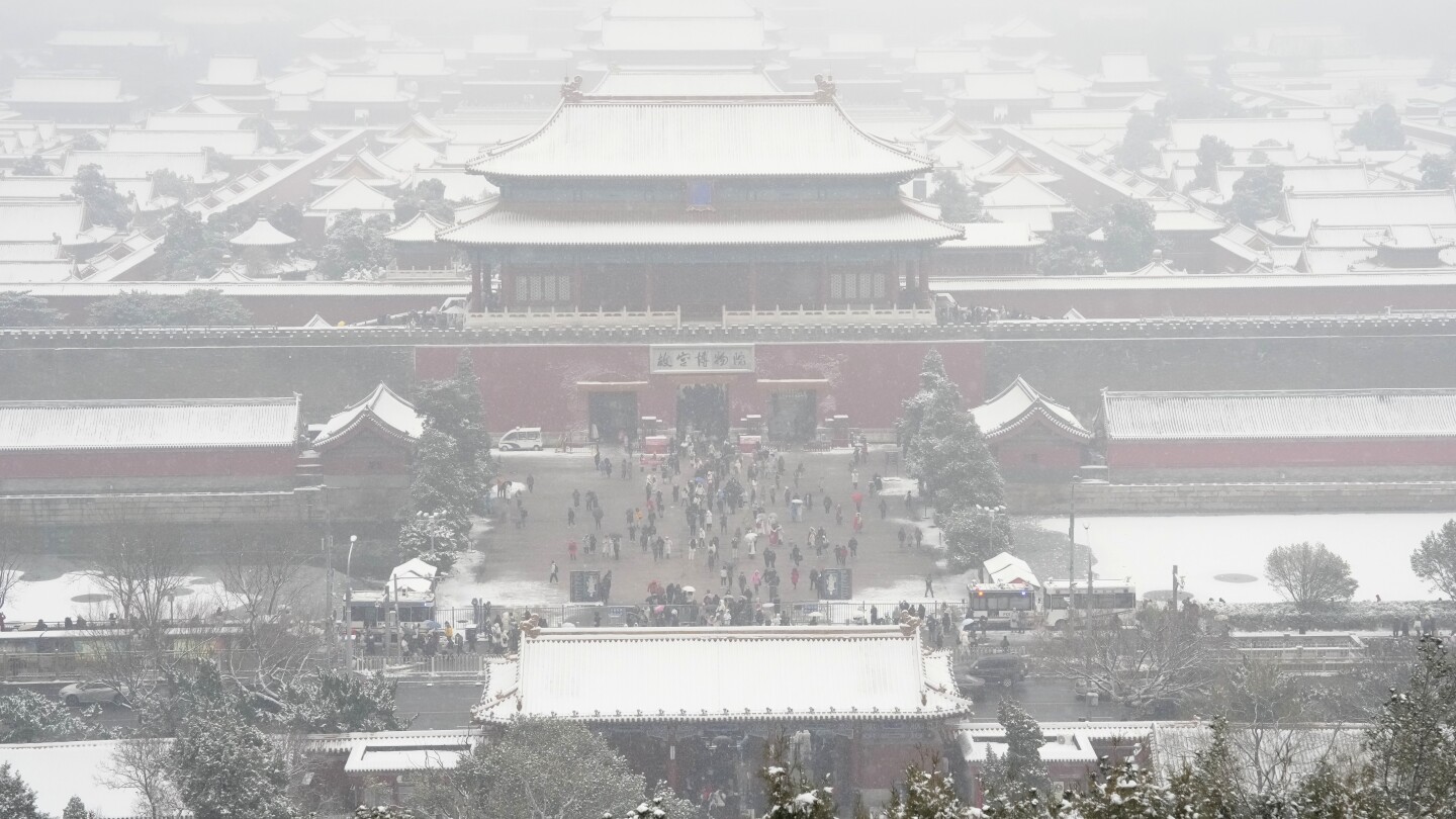 AP PHOTOS: Crowds bundle up to take snowy photos of Beijing’s imperial-era architecture | AP News