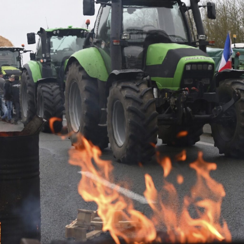 European farmers block French roads and head to Brussels to protest wages and bureaucratic meddling | AP News