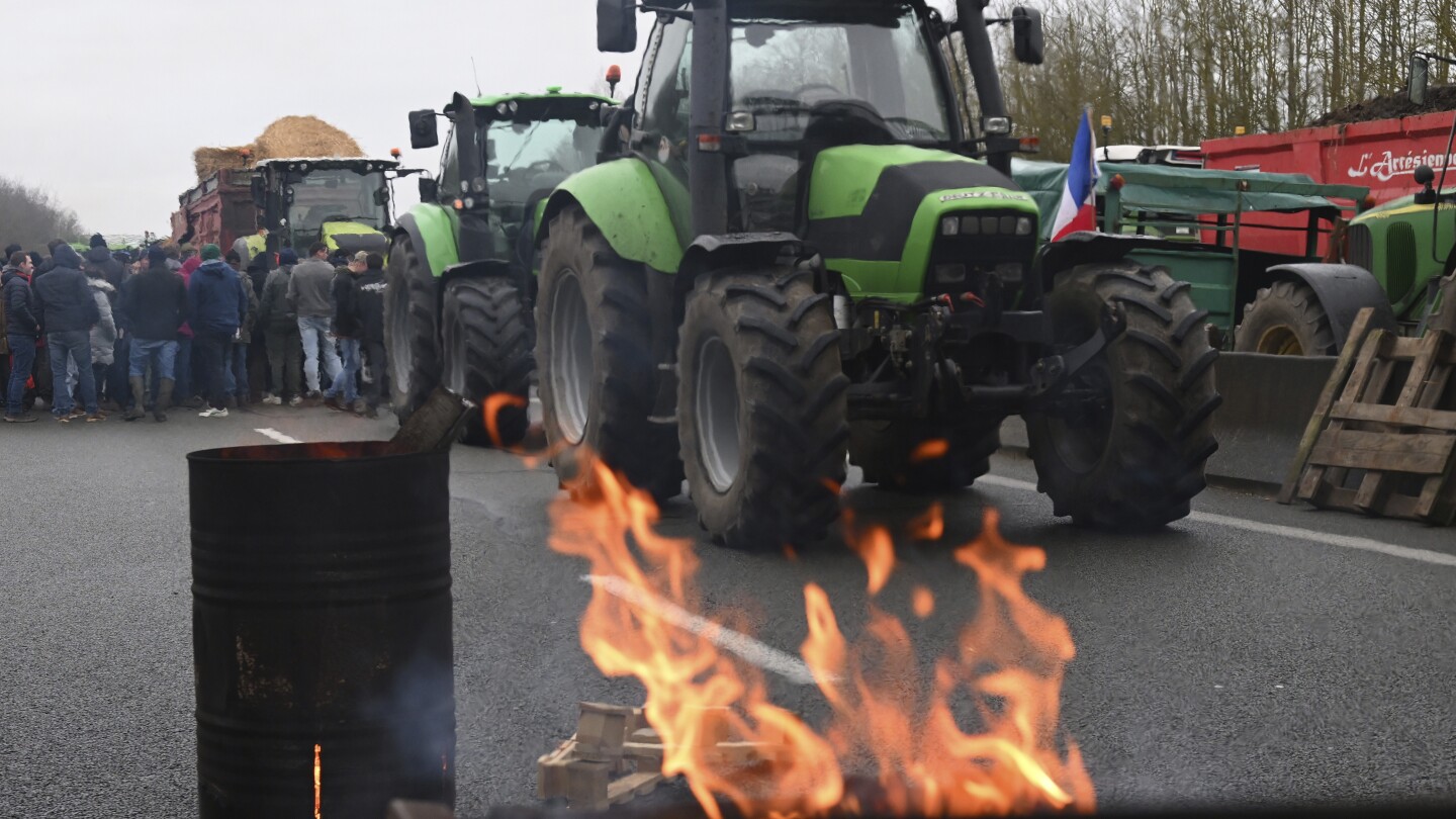 European farmers block French roads and head to Brussels to protest wages and bureaucratic meddling | AP News