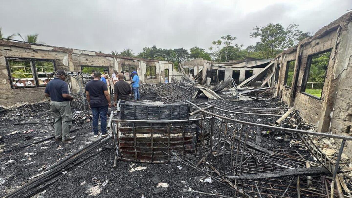 Parents of two girls who survived a dorm fire that killed 20 in Guyana sue the government