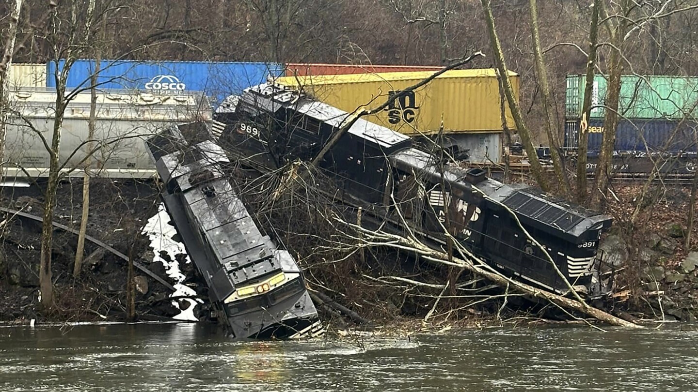 Train derailment leaves cars on riverbank or in water; no injuries, hazardous materials reported