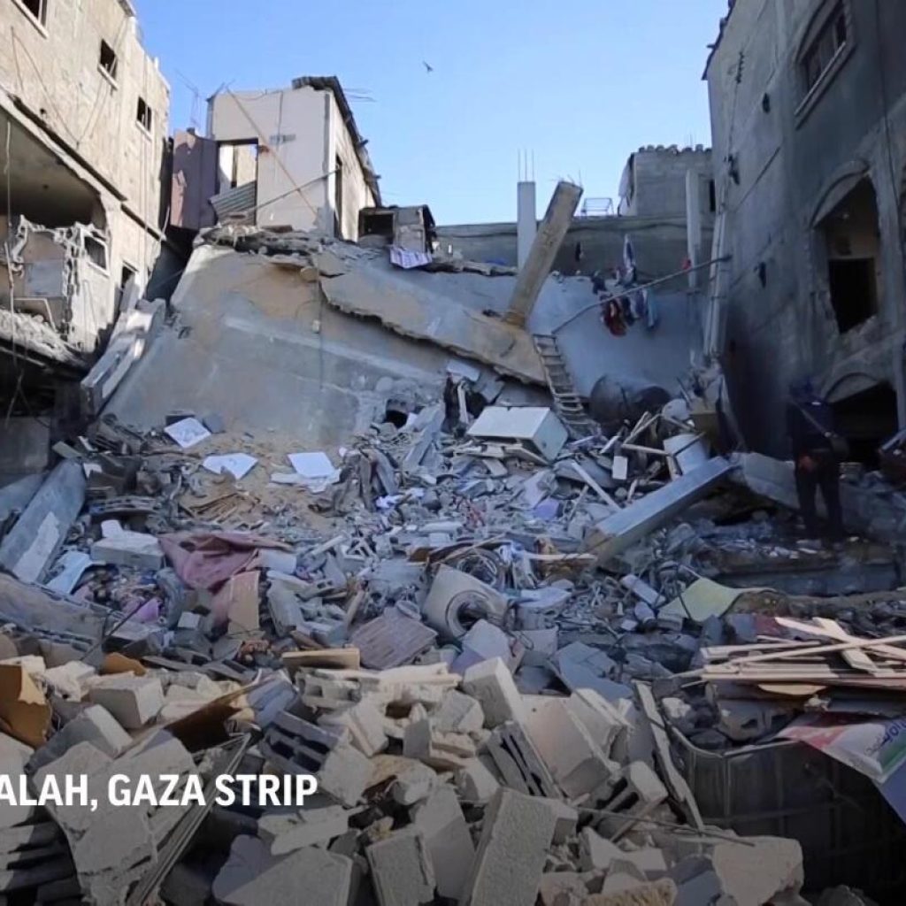 Boy searches through mass of concrete rubble after deadly Israeli strike on central Gaza | AP News