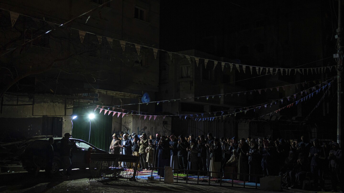 A Gaza family uprooted by war and grieving their losses shares a somber Ramadan meal in a tent