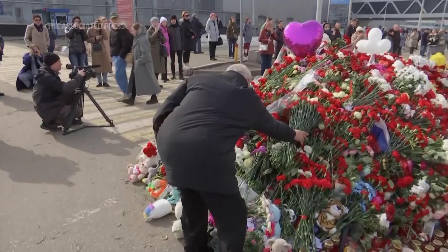 People continue to place flowers at memorial to victims of Russia concert hall attack | AP News