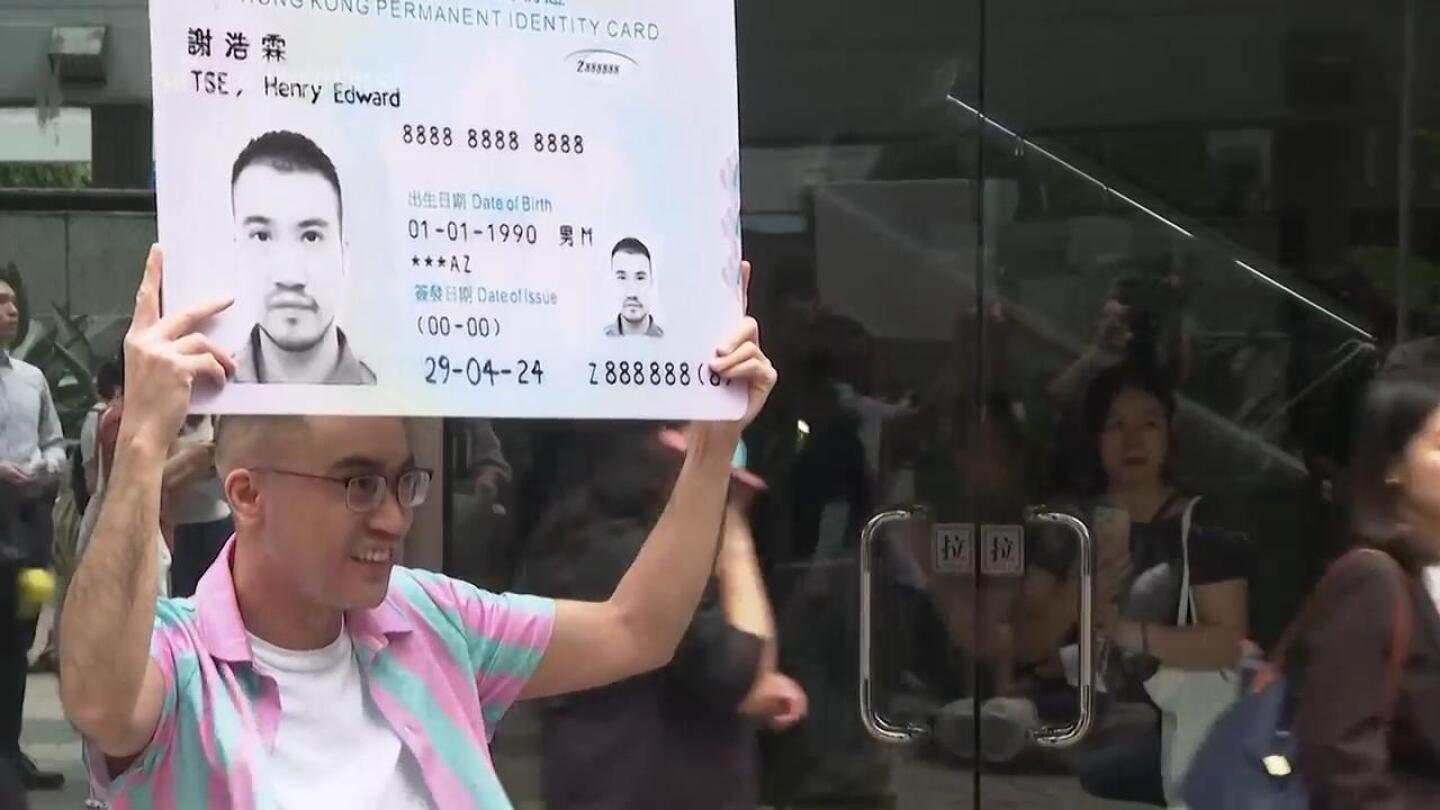 Transgender activist Henry Tse receives his new Hong Kong identity card