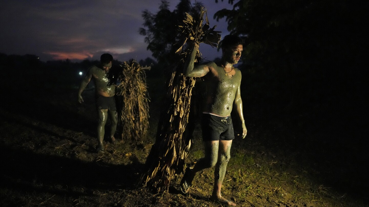 AP PHOTOS: Philippine villagers smear mud on their bodies to show devotion to St. John the Baptist