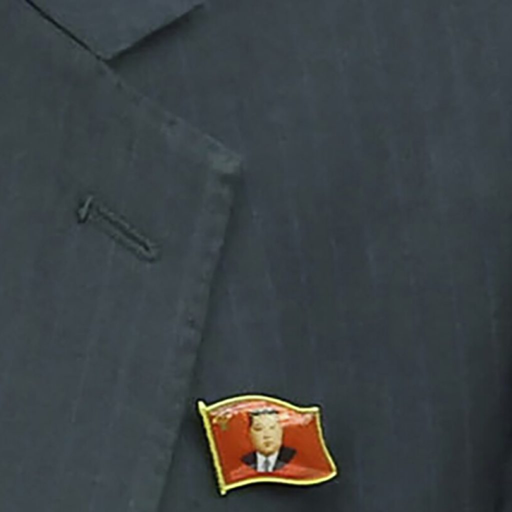 North Koreans are seen wearing Kim Jong Un pins for the first time as his personality cult grows