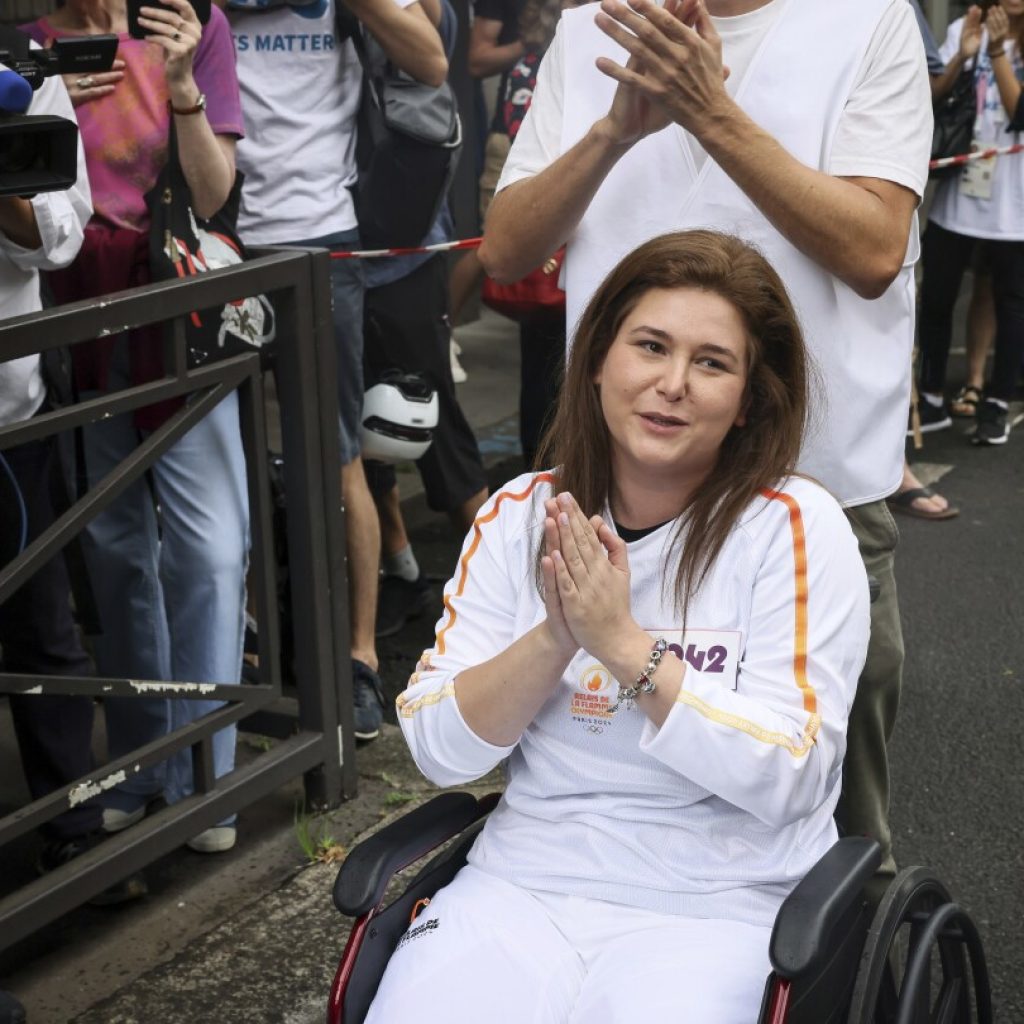 A Lebanese photojournalist, wounded in Israeli strike, carries Olympic torch to honor journalists