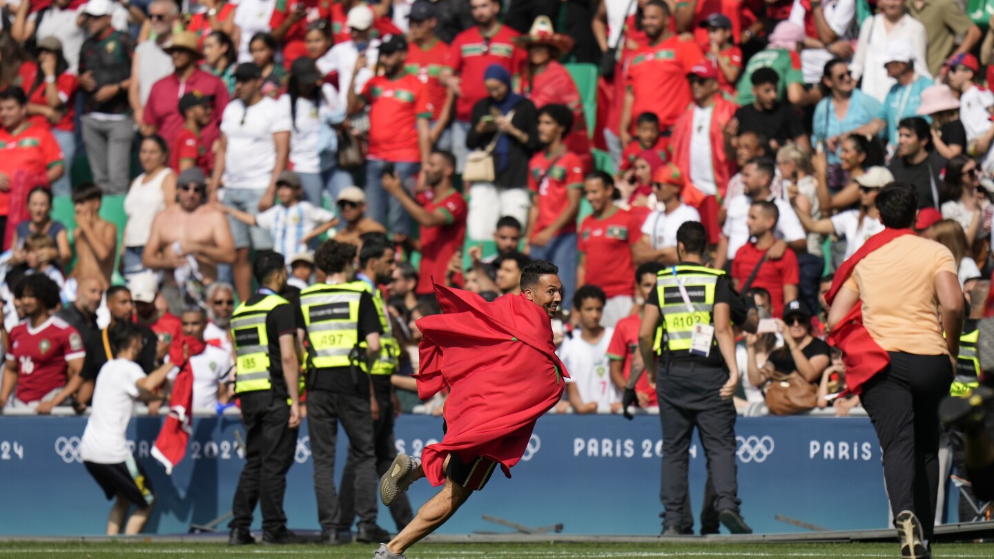 Morocco fans rush field during Olympic soccer opener vs Argentina. Game suspended, goal disallowed