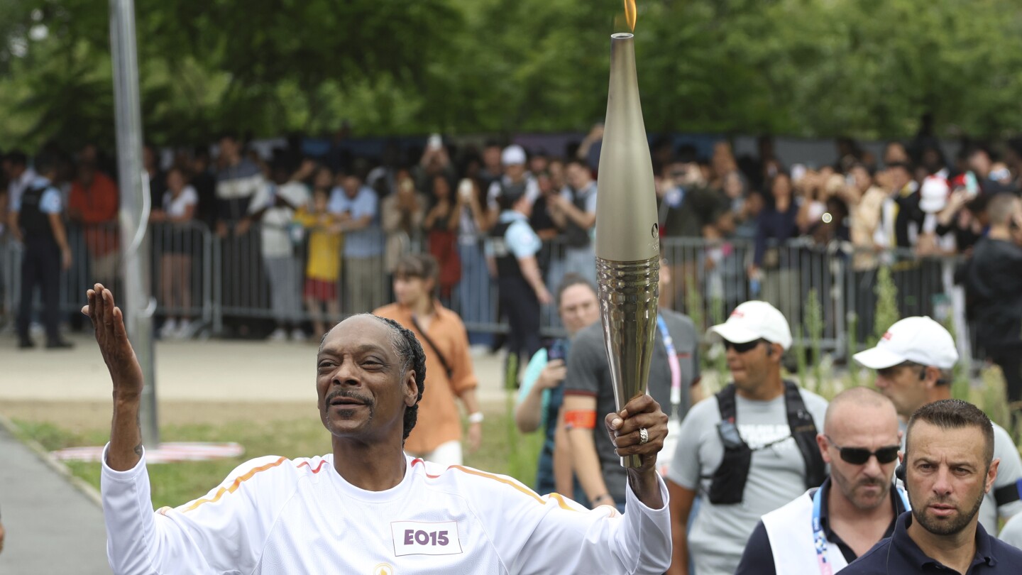 Snoop Dogg carries the Olympic torch before opening ceremony in Paris