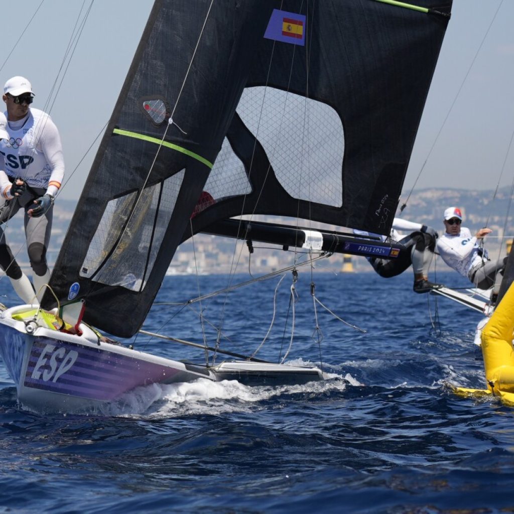 Olympic sailing ready to start with fast windsurfing, bird-like skiffs under light winds, hot sun