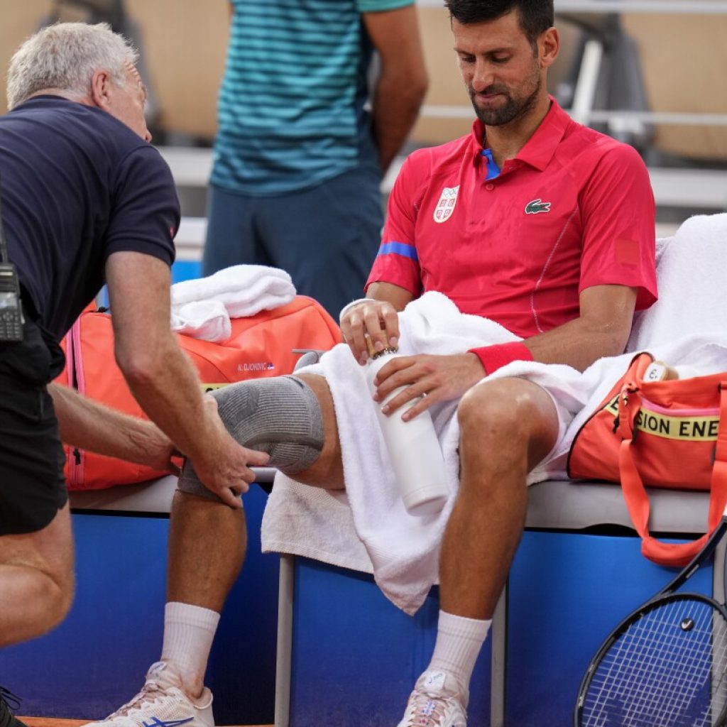 Novak Djokovic’s knee injury bothers him at the Paris Olympics but he beats Stefanos Tsitsipas