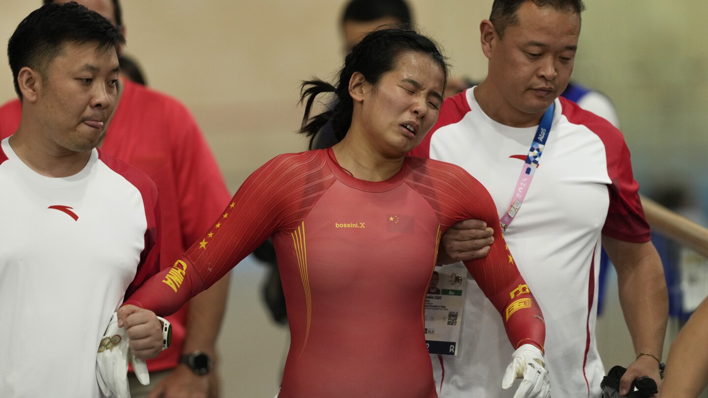 China track cyclist Yuan Liying has to be helped off velodrome after causing hard keirin crash