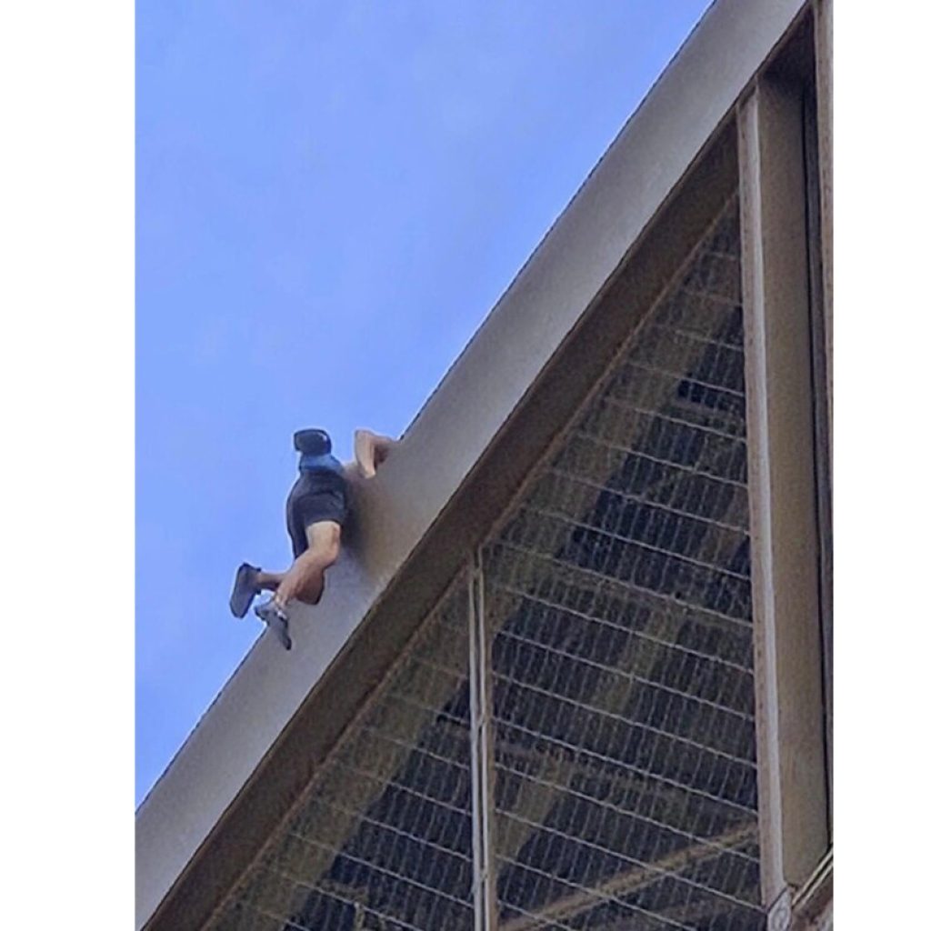 A man is seen climbing the Eiffel Tower, prompting an evacuation hours before closing ceremony