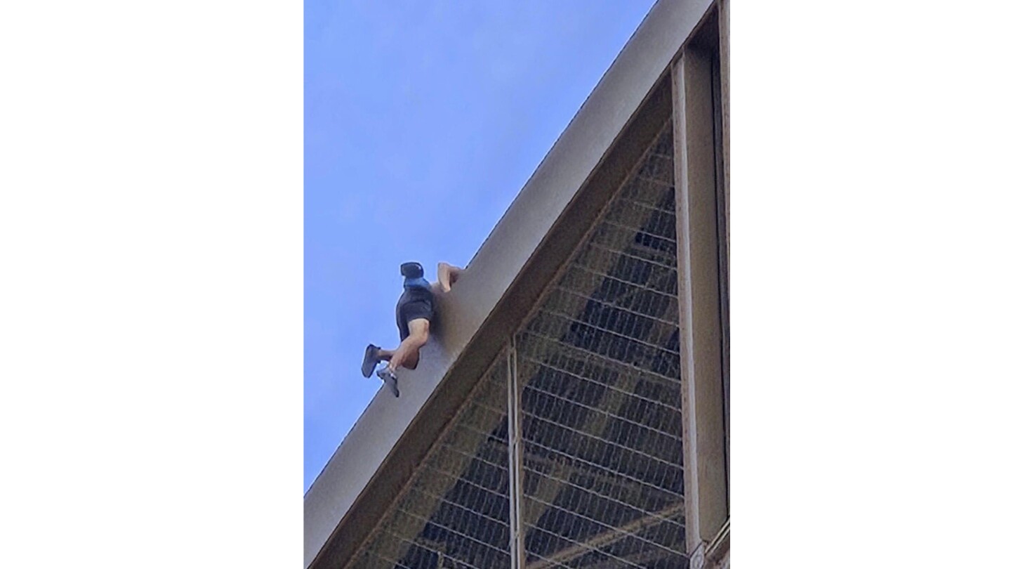 A man is seen climbing the Eiffel Tower, prompting an evacuation hours before closing ceremony