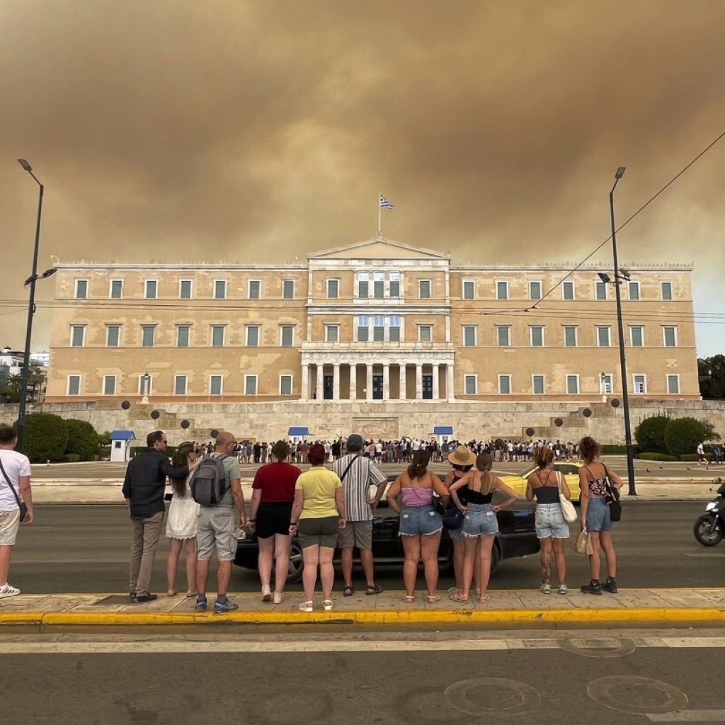 A wildfire near Greece’s capital darkens the skies over Athens and advances fast