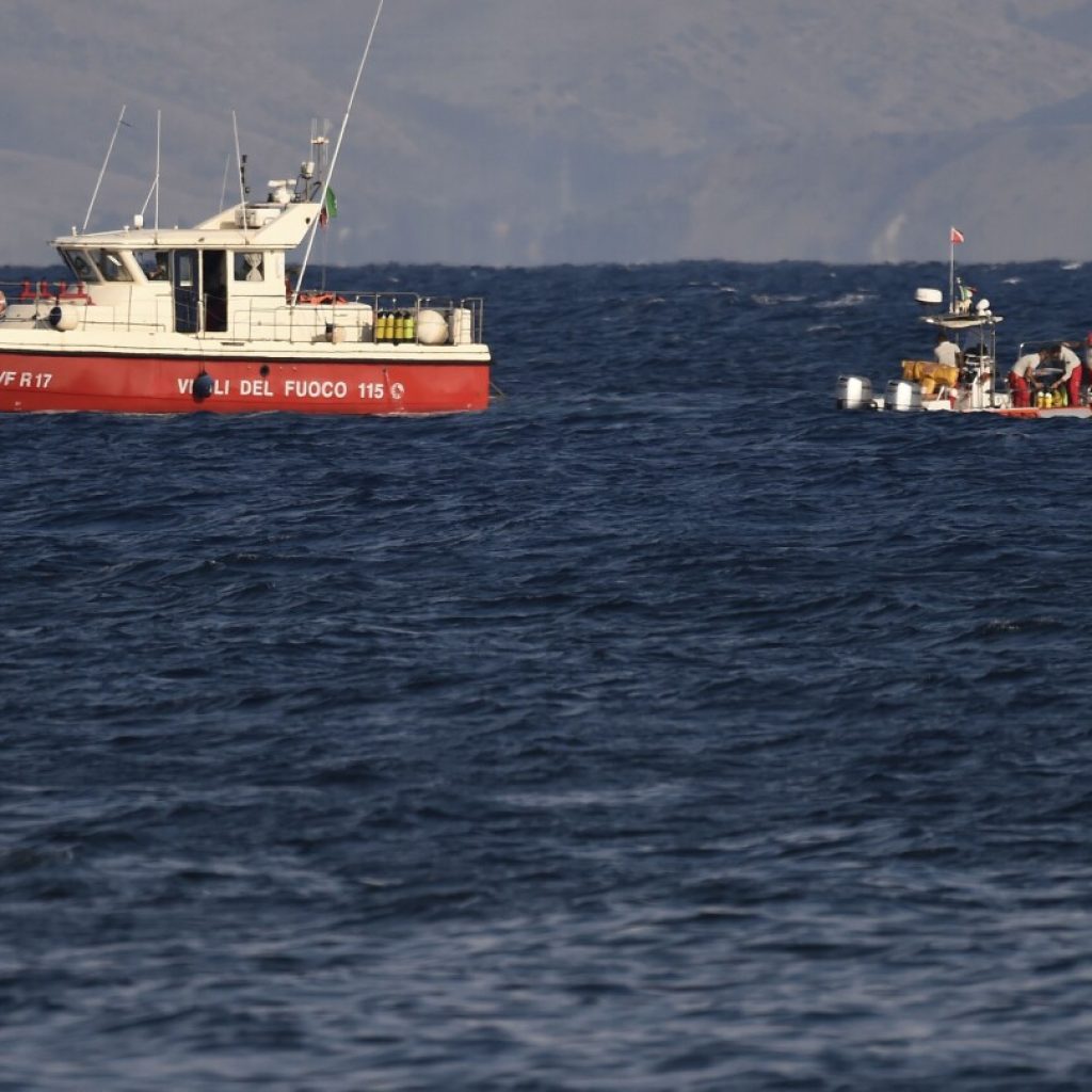 Rescue crews unload body bag in Sicily port as search continues after yacht sinking