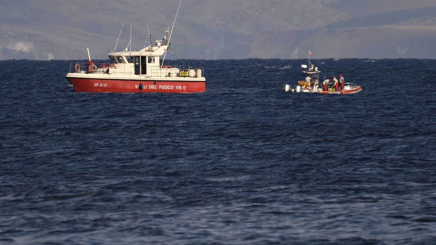 Rescue crews unload body bag in Sicily port as search continues after yacht sinking