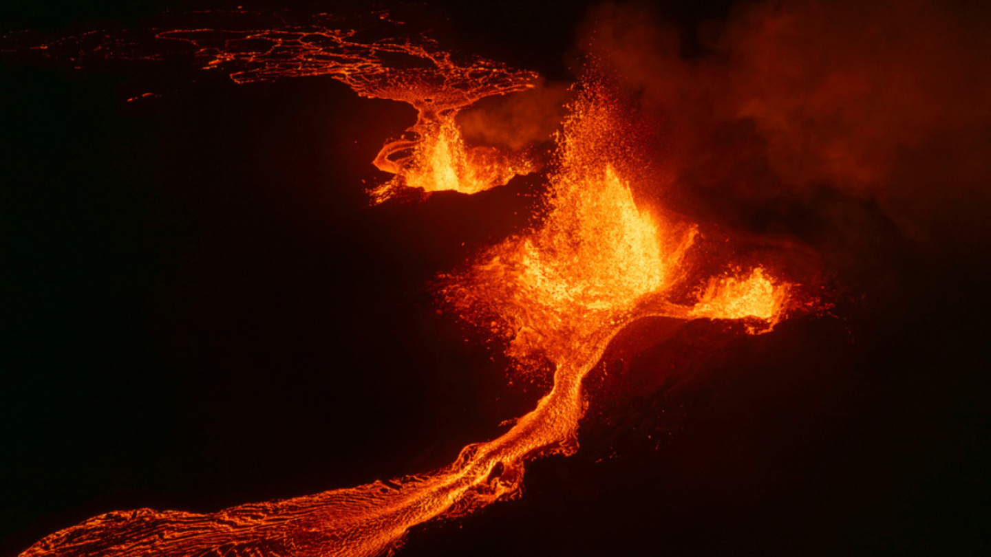 Northern lights shine in night sky as lava spews from erupting volcano in Iceland | AP News