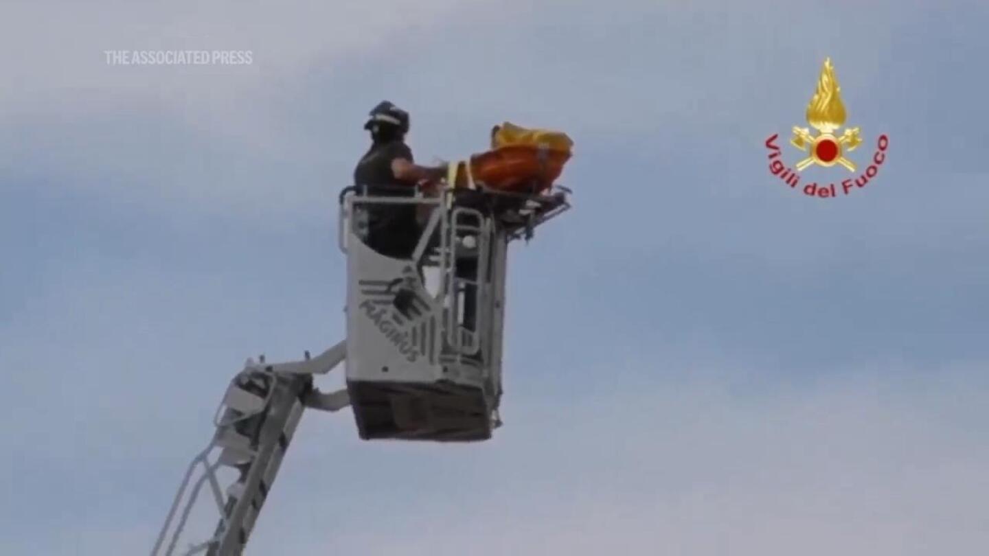 Watch the moment firefighters rescue a tourist from the leaning tower of Pisa | AP News