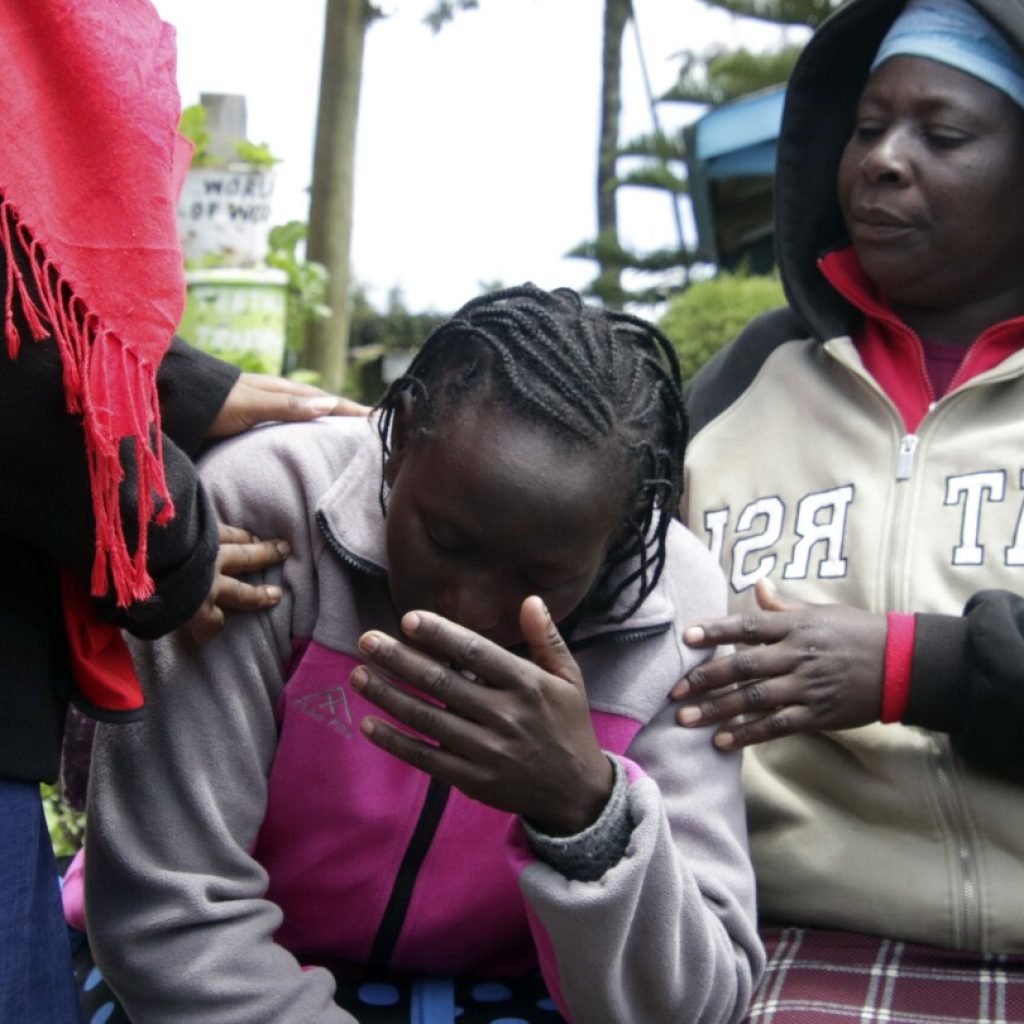 Kenyan officials remove bodies as they try to confirm the death toll from a school dormitory fire