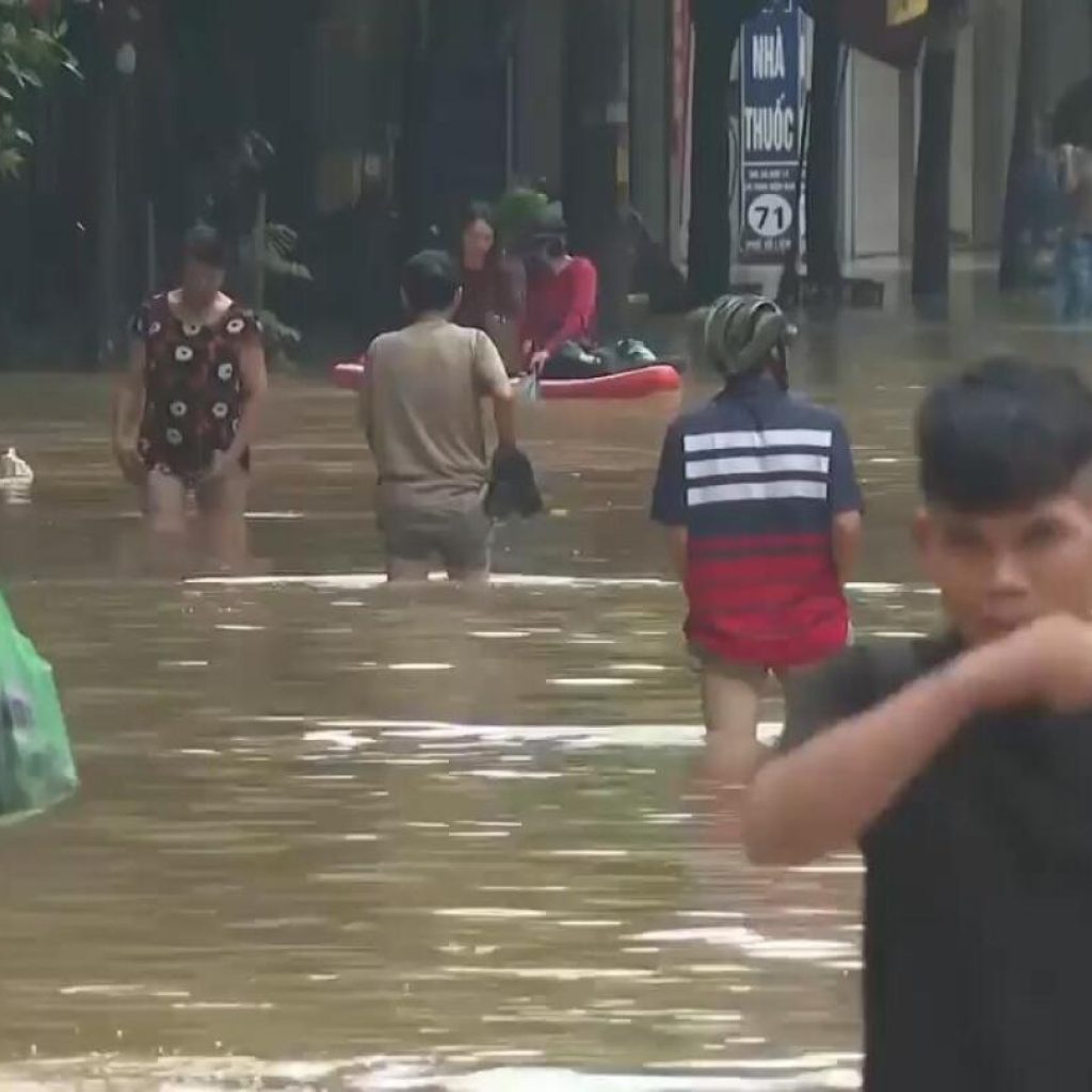 People in Hanoi wade through flood waters in wake of Typhoon Yagi | AP News