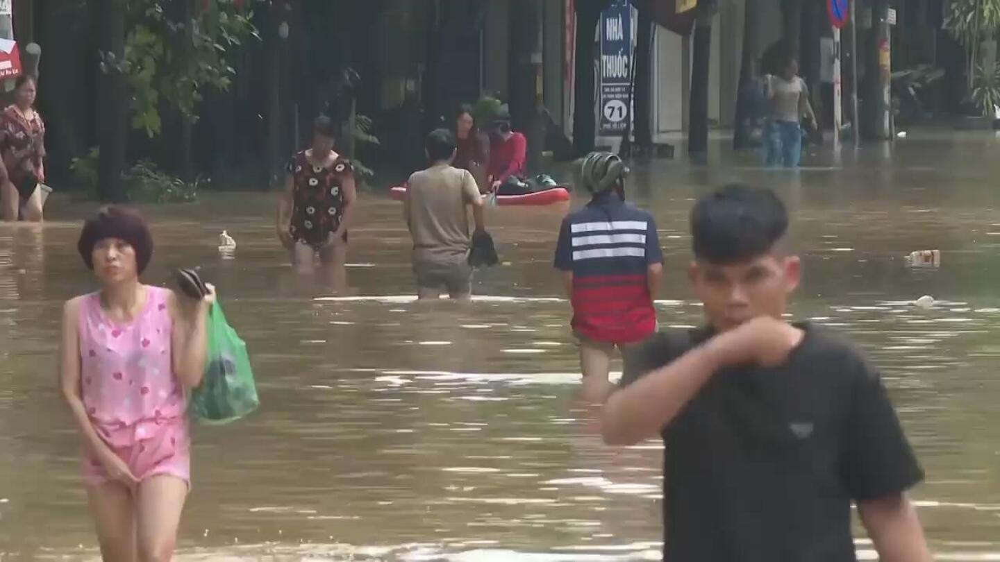 People in Hanoi wade through flood waters in wake of Typhoon Yagi | AP News