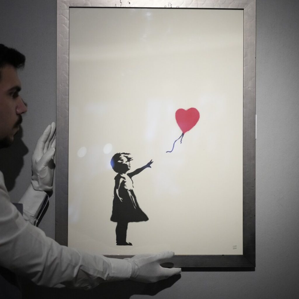 2 men charged with stealing a famous Banksy image from a London art gallery