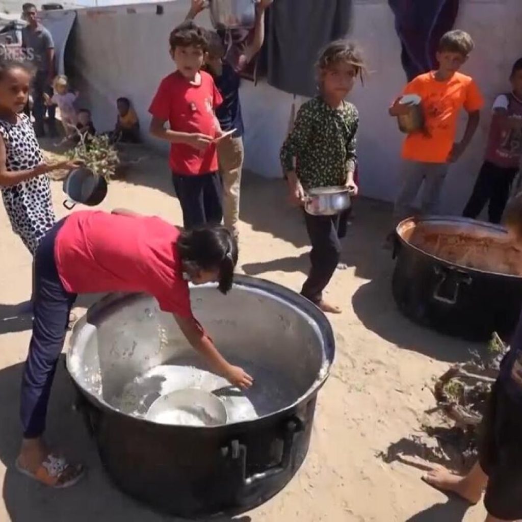 Displaced Palestinians in central Gaza face daily wait for food and queues for water | AP News